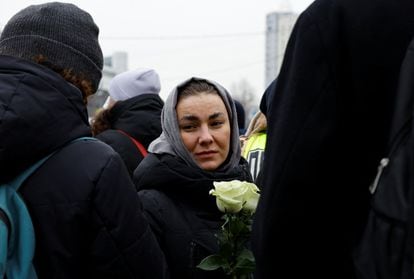 A woman holds white carnations outside the Moscow church this Friday. 