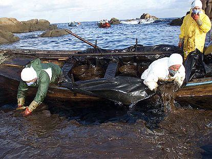 <i>Percebeiros</i> recogen chapapote en Santa Mariña (A Coruña). Los pescadores retiraron 40.000 toneladas de fuel mezclado con agua.