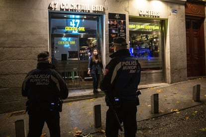 Las ciudades de todo el país volvieron a quedarse desiertas esta madrugada tras el toque de queda impuesto por el Gobierno para tratar de controlar la pandemia. En la imagen, agentes de la Policía Municipal informan a una ciudadana en el centro de Madrid.