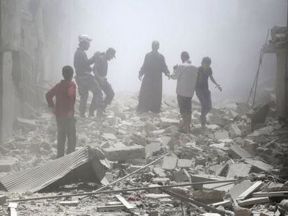 Residentes de Alepo entre los escombros tras un bombardeo.