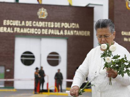 Una mujer coloca flores en memoria de las víctimas del atentado en Bogotá.