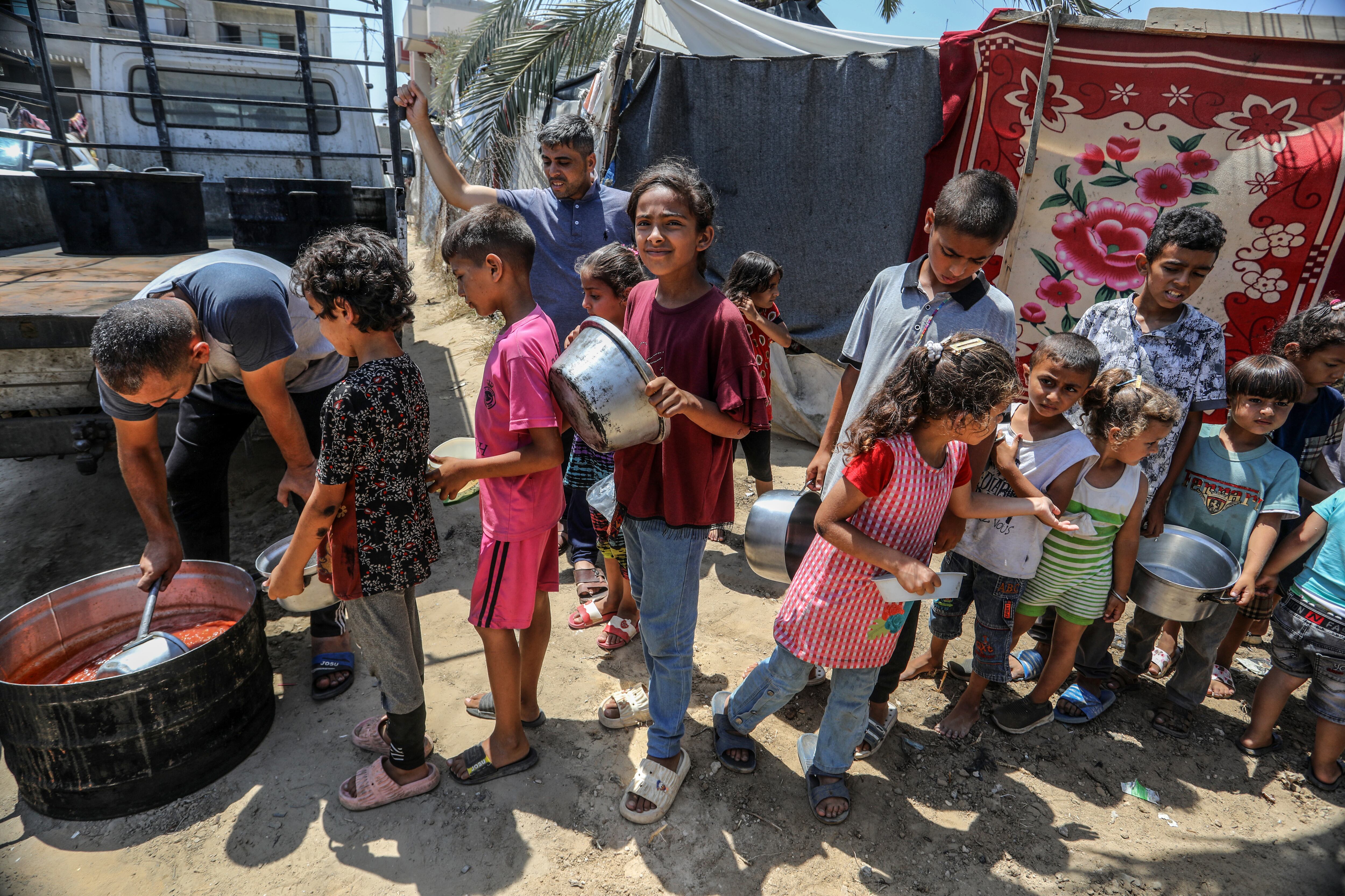 Niños palestinos esperando para recibir comida en Gaza.