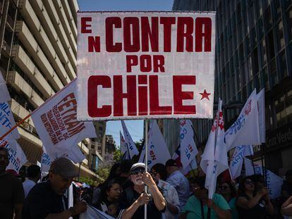 Un hombre sostiene un cartel a favor del voto en contra en el plebiscito constitucional, el 14 de diciembre.