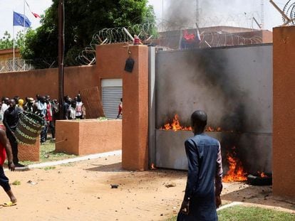 Partidarios de la Junta Militar protestan ante la Embajada de Francia e intentan incendiarla, este domingo en Niamey.