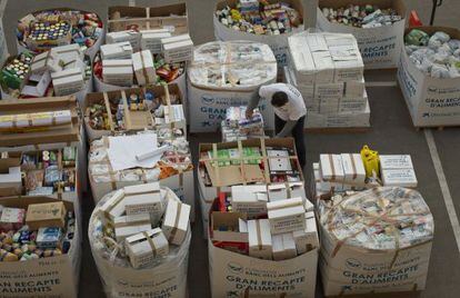 Un voluntario ordena los contenedores de cartón en el almacén del Banco de los Alimentos, en Barcelona.