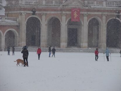 Varios ciudadanos pasean bajo una intensa nevada en la localidad madrileña de Aranjuez el pasado jueves. 
