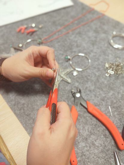 A user of Albero Artesanos making jewelry with pliers.