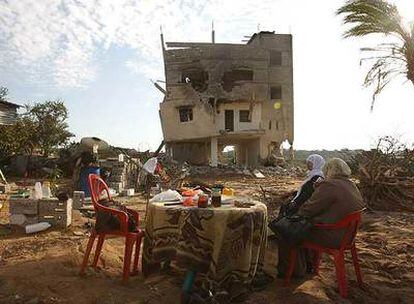 Dos palestinas toman un refrigerio con lo que han recuperado de su casa destruida en Yabalia (norte de la franja de Gaza).