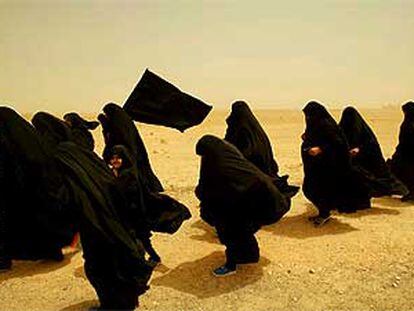 Mujeres iraquíes chiíes caminan en peregrinación rumbo a la ciudad santa de Kerbala a través de una tormenta de arena en el desierto.