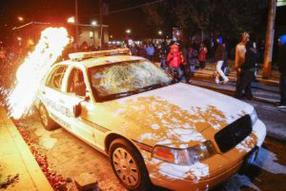 Una bomba incendiaria es lanzada contra un coche de policía.