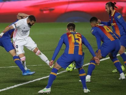 El delantero francés del Real Madrid Karim Benzema intenta un lanzamiento ante varios rivales del Barcelona.