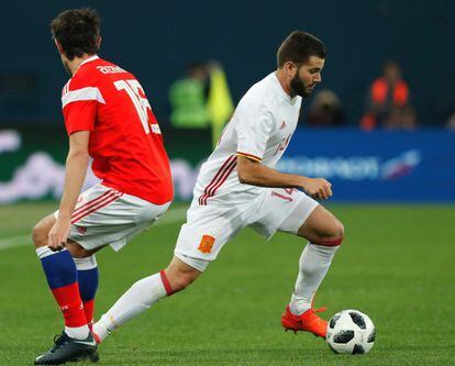 El jugador ruso Yuri Zhirkov (izda.) pelea por el control del balón con el jugador español Nacho Fernández.