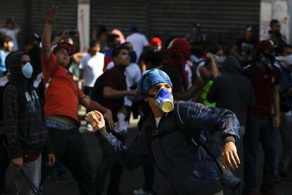 Un joven opositor se prepara para lanzar una piedra a la policía durante los enfrentamientos que tuvieron lugar en Caracas.