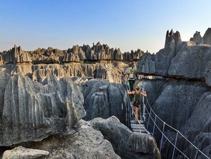 Una pareja de turistas cruza un puente colgante en la reserva de Tsingy de Bemaraha, en Madagascar.