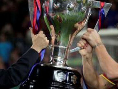 El presidente de la Real Federación Española de Fútbol, Angel María Villar, entrega la copa de campeón de liga al capitán del F.C. Barcelona, Carles Puyol.