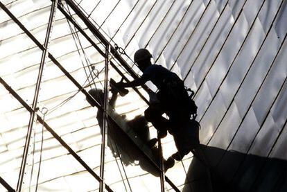Uno de los escaladores del equipo de limpieza trabaja en la fachada del Museo Guggenheim de Bilbao.