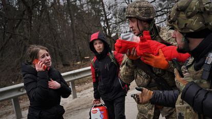 El militar Vlod sostiene a una niña junto a su madre.