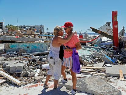 Dos mujeres que han perdido sus negocios se abrazan tras el paso del huracán Ian por la isla de Fort Myers Beach, en Florida, el 30 de septiembre de 2022.