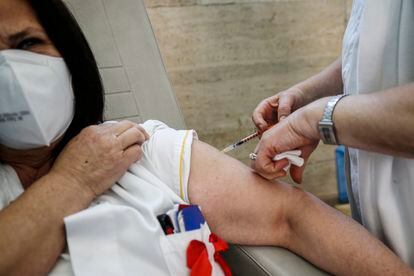 Una sanitaria vacuna a una mujer en un hospital de Roma. 