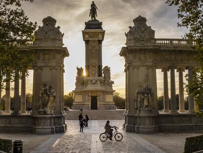 Una chica disfruta de un agradable paseo en bicicleta al atardecer antes de volver a casa en el parque del Retiro.