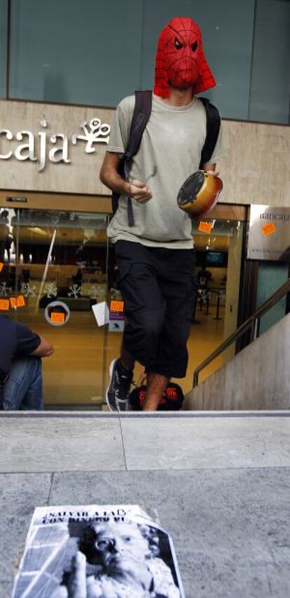 Un joven golpea una cacerola en el acceso a la sede central de Bancaja.