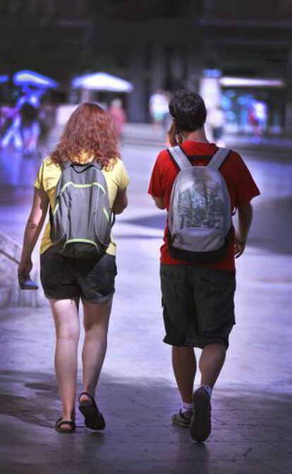 Dos jóvenes con mochilas en Valencia.
