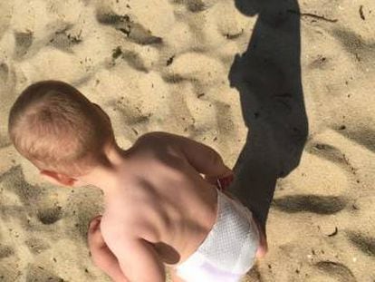 Un beb&eacute; juega en una playa gallega.