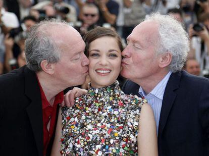 Los hermanos Jean-Pierre (derecha) y Luc Dardenne besan a la actriz francesa Marion Cotillard durante el pase gráfico de la película 'Deux Jours, Une Nuit' (Dos Días, una noche) en la 67ª edición del Festival de Cannes.