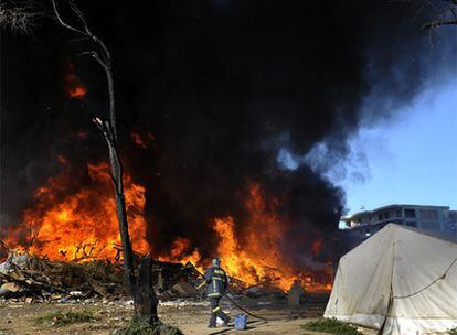 Un bombero intenta apagar el incendio que arrasó el campamento ilegal de inmigrantes de Patras, desmantelado por la policía el 12 de julio.