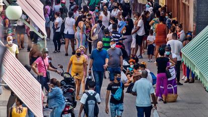 Varias personas caminan para entrar a tiendas en la calle Obispo, el viernes 28 de enero del 2022, en La Habana, Cuba.