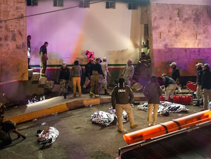 Funcionarios del INM en Ciudad Juárez, junto a los cuerpos de migrantes muertos en el incendio del 28 de marzo.