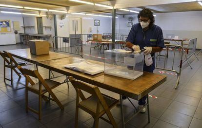 Una trabajadora desinfecta una urna para las elecciones catalanas en un colegio de Girona.