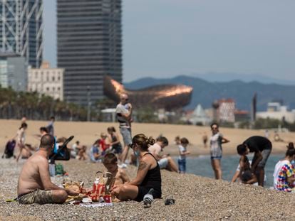 Personas tomando el sol en la playa de la Barceloneta de Barcelona, este sábado.