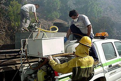 Bomberos y otros operarios combaten el fuego que ha asolado más de 400 hectáreas en El Hierro.