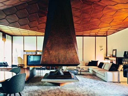 El salón como espectáculo: la chimenea es de cobre y el techo, de madera de nogal con forma de panel de miel. |