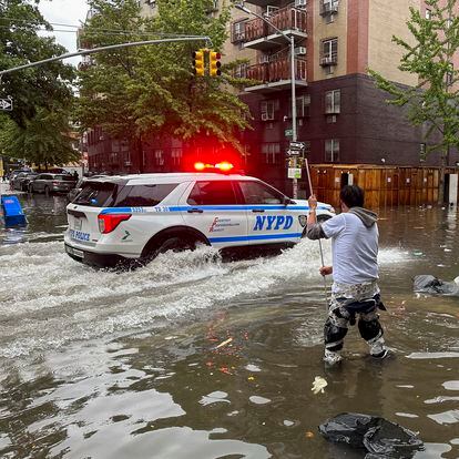 A man works to clear a drain in flood waters, Friday, Sept. 29, 2023