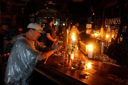 Clientes en un bar sin luz durante la  "Fiesta de huracanes" en Wilmington, Carolina del Norte.