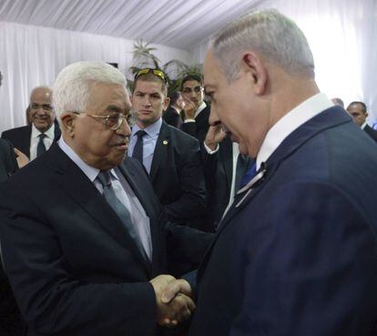 El primer ministro israelí, Benjamin Netanyahu (d), saluda al presidente palestino, Mahmud Abás, durante el funeral de estado del expresidente israelí y premio Nobel de la Paz, Simón Peres, en el cementerio del Monte Herzl, en Jerusalén.