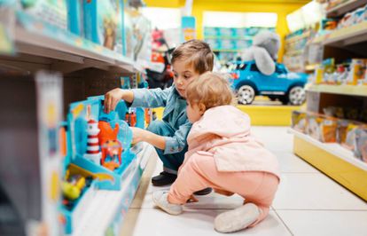 Dos niños eligen varios juguetes en una tienda de juguetes.