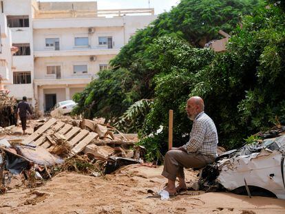 Un hombre se sienta sobre un coche destruido, tras la inundación registrada en Derna, el 12 de septiembre.