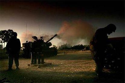 Soldados israelíes observan los disparos de un blindado desde el límite de la frontera con Gaza.