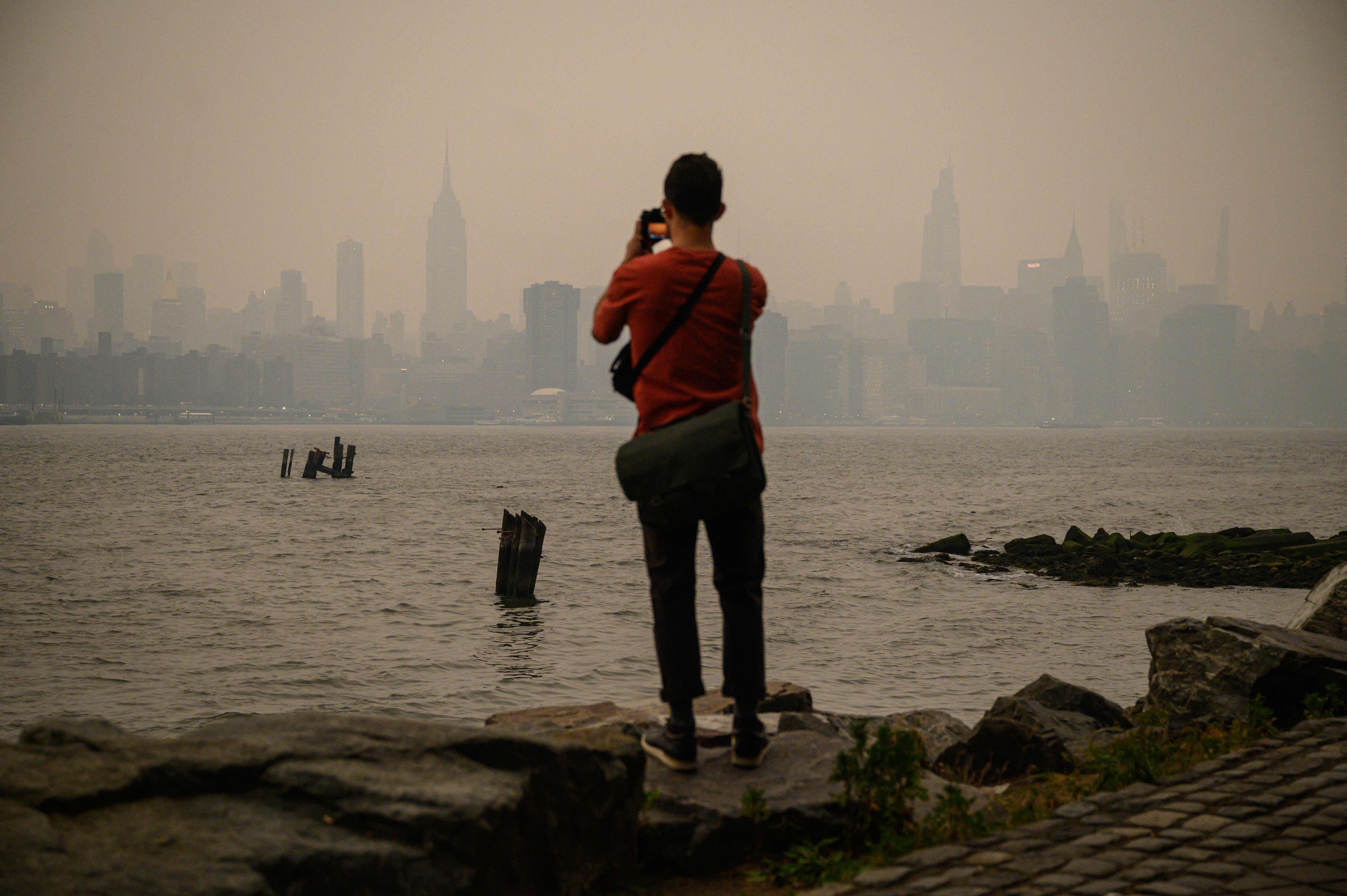 Un hombre hace una foto al 'Skyline' de Nueva York desde Brooklyn, el martes.