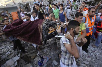 El cuerpo sin vida de una mujer palestina es transportado por un grupo de palestinos.