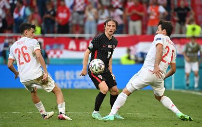 Modric lanza un pase entre Pedri y Oyarzabal