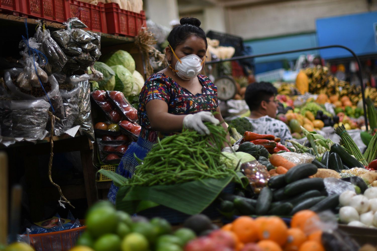 Una mujer vendedora de vegetales en un mercado de ciudad de Guatemala.