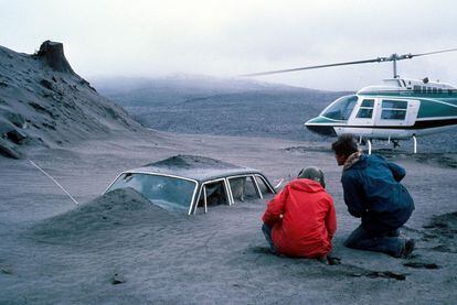Geólogos observan un coche semienterrado por la ceniza de la erupción del monte Santa Helena (noroeste de EE UU), en 1980.