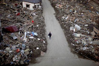 Una mujer anda en una calle de Taro, localidad del noreste de Japón arrasada por el tsunami.