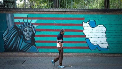 Un hombre camina junto a un mural antiamericano en Teherán.