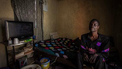 Mohamed Diop, de 40 años, sentado en la cama de su modesta habitación, en el barrio de Yoff Nbenguene. Padece una neuropatía congénita que le dificulta el movimiento.