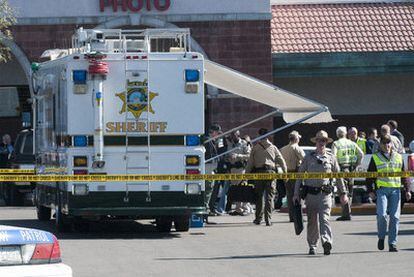 Miembros de los servicios de emergencia y de seguridad trabajan en la zona del crimen, en Tucson.